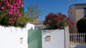A gated entrance with a green door, a white wall, and a small mailbox. - Beautiful  villa for 4 guests with A/C, WIFI, TV and terrace (Le Grau-du-roi)