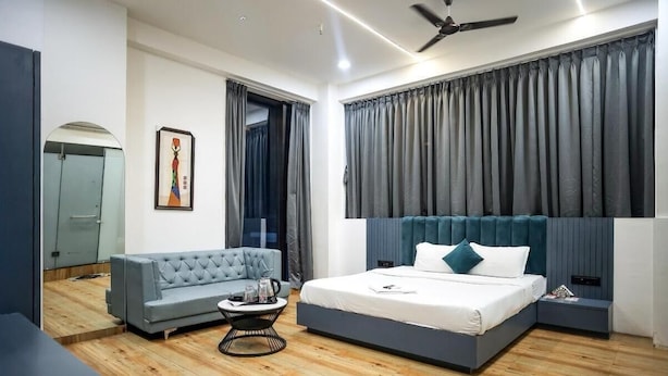 Quarto moderno com cama, sofá, mesa de centro e um quadro na parede.