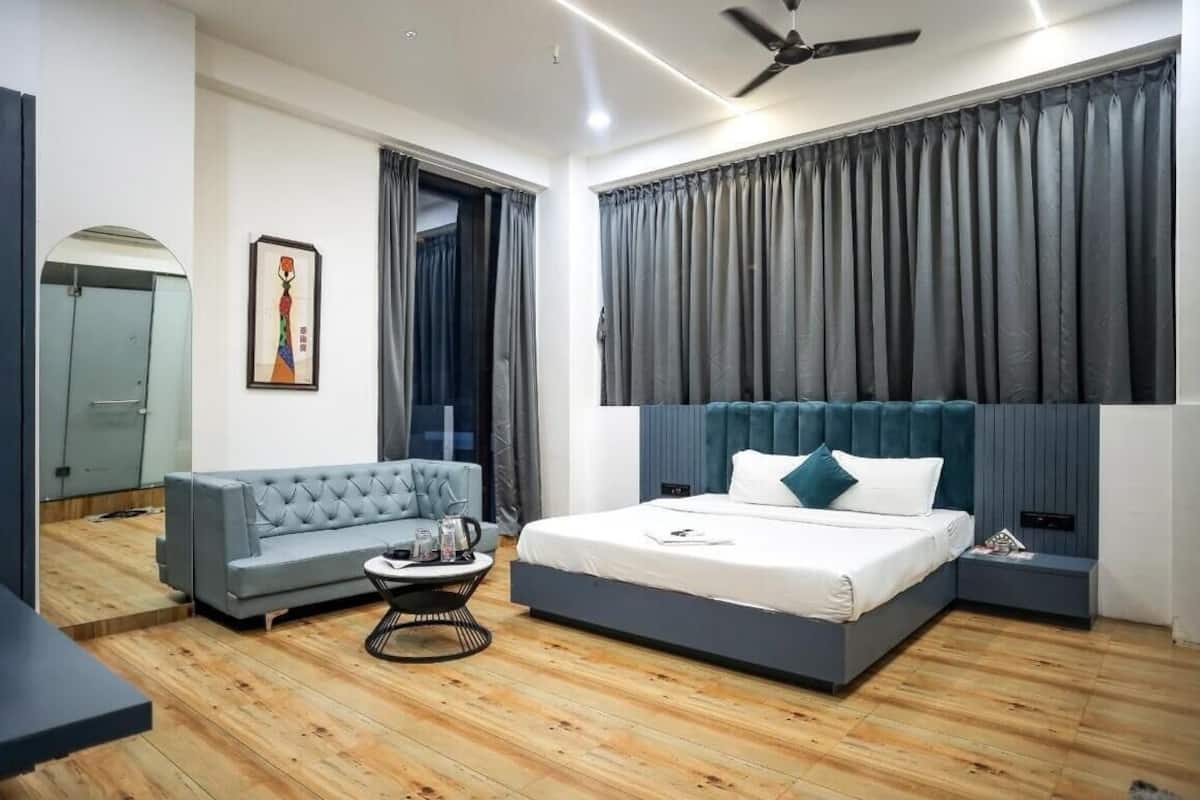 Ein modernes Schlafzimmer mit Bett, Sofa, Couchtisch und einem Gemälde an der Wand.