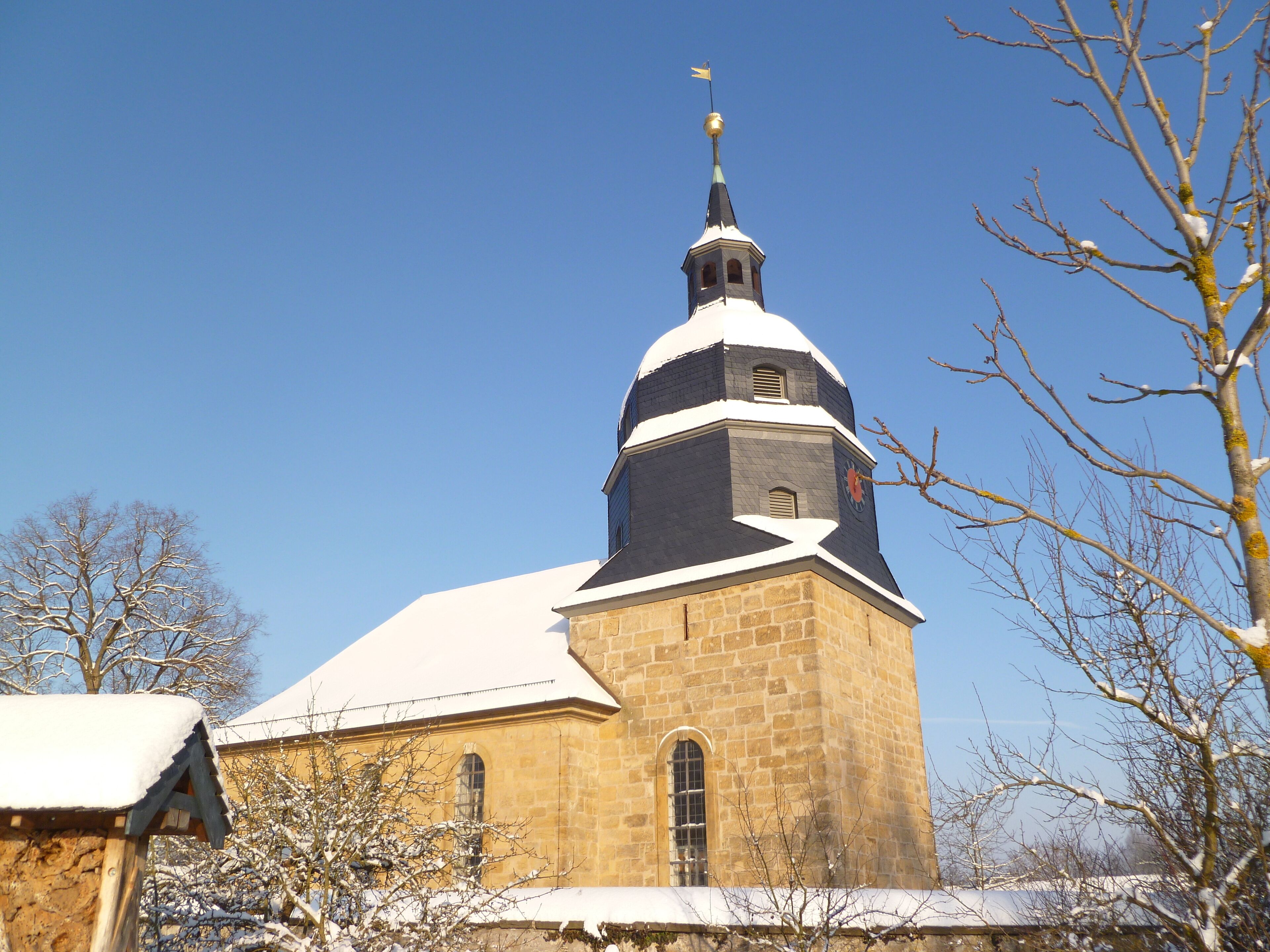 Une église dotée d’un clocher imposant et d’une tour horloge.