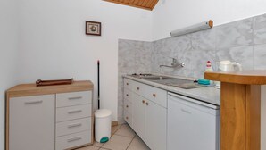 A compact kitchen with a wooden ceiling, white cabinets, a sink, and a small countertop. - Nice apartment for 2 guests with WIFI, A/C, TV and terrace (Pokrivenik)