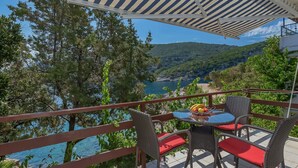 A terrace with wicker chairs and a table, overlooking a scenic coastal view. - Nice apartment for 2 guests with WIFI, A/C, TV and terrace (Pokrivenik)