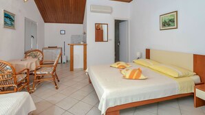 A bedroom with a bed, a desk, a chair, and a bathroom door. - Nice apartment for 2 guests with WIFI, A/C, TV and terrace (Pokrivenik)