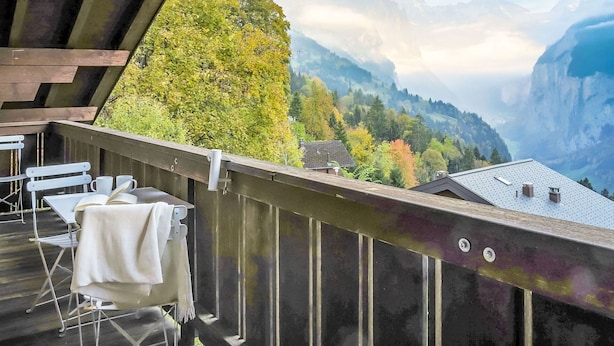 Un balcone con vista sulle montagne e il foliage autunnale.