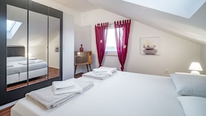 Ein modernes Schlafzimmer mit einem großen Bett, einem Fernseher auf einem kleinen Tisch und einem Oberlicht.