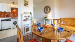 Un ambiente compatto con angolo cottura, zona pranzo e area salotto.
