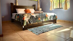 A bedroom with a bed, curtains, a nightstand, and a window. - Casa midin 9, Stunning 3bd 2bth condo, GREAT location! (Puerto Carrillo)