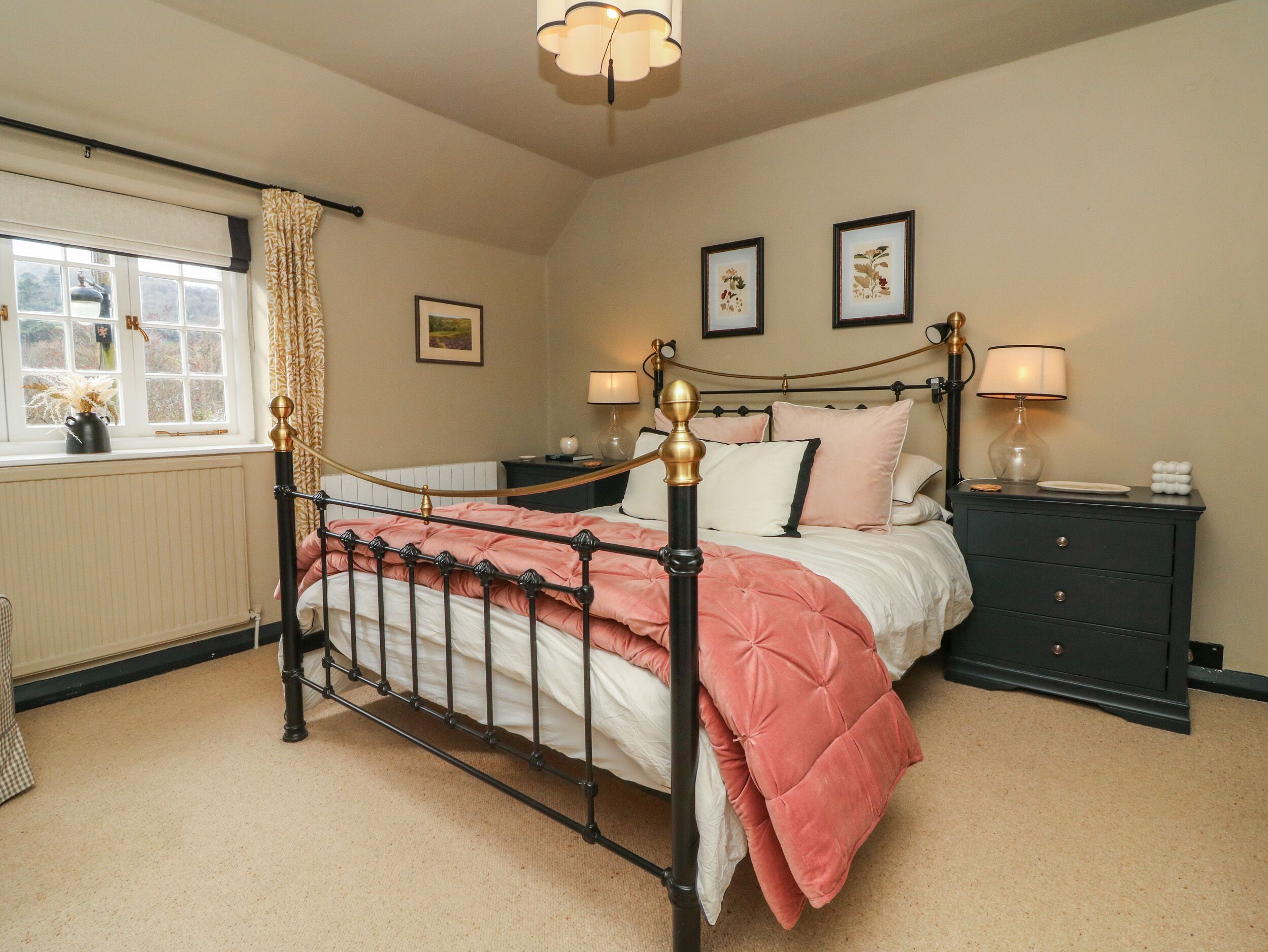 A neatly arranged bedroom with a bed, bedside tables, and a window with curtains.