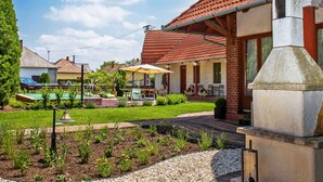 A residential property with a swimming pool, outdoor seating, and a stone chimney.