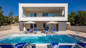 A modern two-story house with a swimming pool and outdoor seating area. - Seaview villa Deep Green in Maslenica (Maslenica)