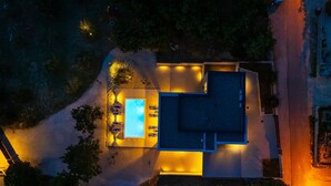 An aerial view of a house with a swimming pool, a covered patio, and a well-lit driveway. - Seaview villa Deep Green in Maslenica (Maslenica)