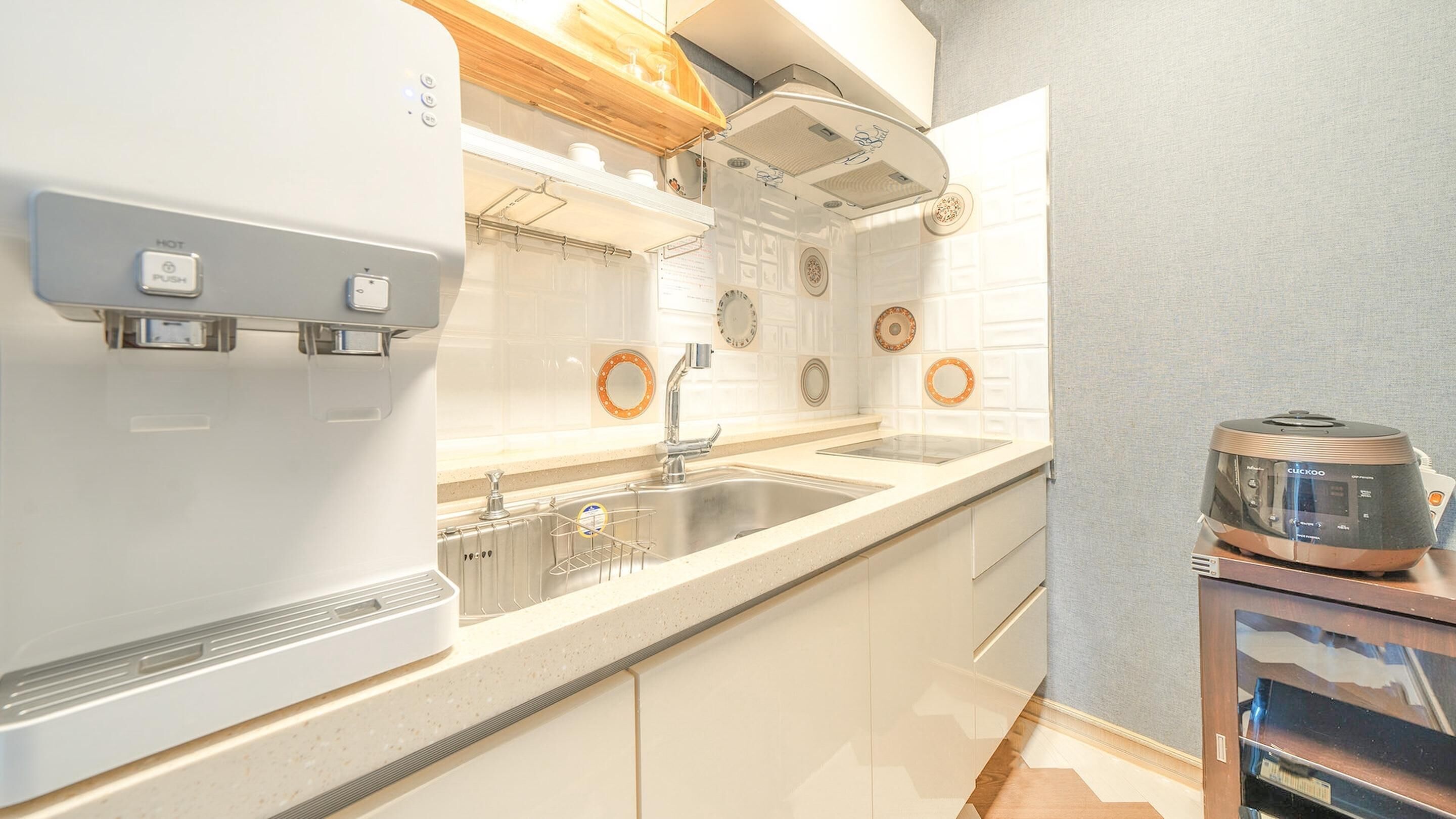 Una cocina moderna con horno empotrado, un lavamanos y una cafetera.