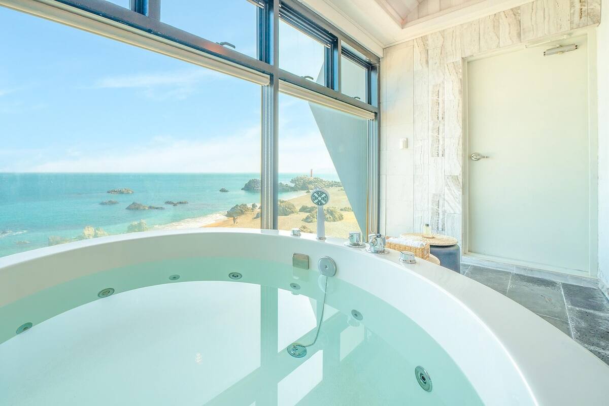 Eine große Badewanne mit Blick auf den Ozean und den Strand.