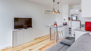 Ein modernes Apartment mit Wohnzimmer, Küche und Essbereich.