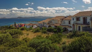 A coastal village with terracotta-roofed houses, a clear blue sea, and a mountainous backdrop. - Beautiful apartment for 5 people with WIFI, A/C, TV and terrace (Regia Dogana)