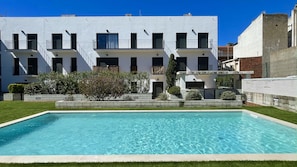 Un edificio moderno con una piscina di fronte.