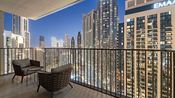 A balcony with a cityscape view, featuring high-rise buildings and a prominent EMAAR building. - WORLD CLASS | 2BR | Downtown View (Downtown)