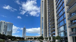 A modern hotel with a swimming pool, high-rise buildings, and a clear sky. - WORLD CLASS | 2BR | Downtown View (Downtown)