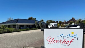 A sign for 'Yperhof Bungalow Park' with a clear view of a building and a gravel driveway. - 3 bedroom accommodation in Julianadorp aan Zee (Julianadorp aan Zee)