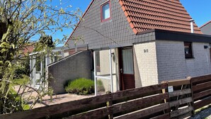 A house with a red-tiled roof, a brick facade, and a number '25' on the wall. - 3 bedroom accommodation in Julianadorp aan Zee (Julianadorp aan Zee)