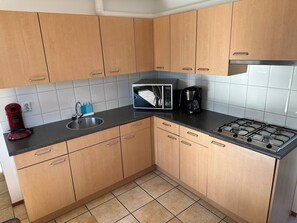 Fridge, stovetop, dishwasher, coffee/tea maker