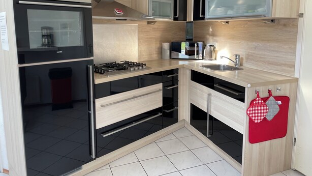 A modern kitchen with a built-in oven, microwave, and gas stove.