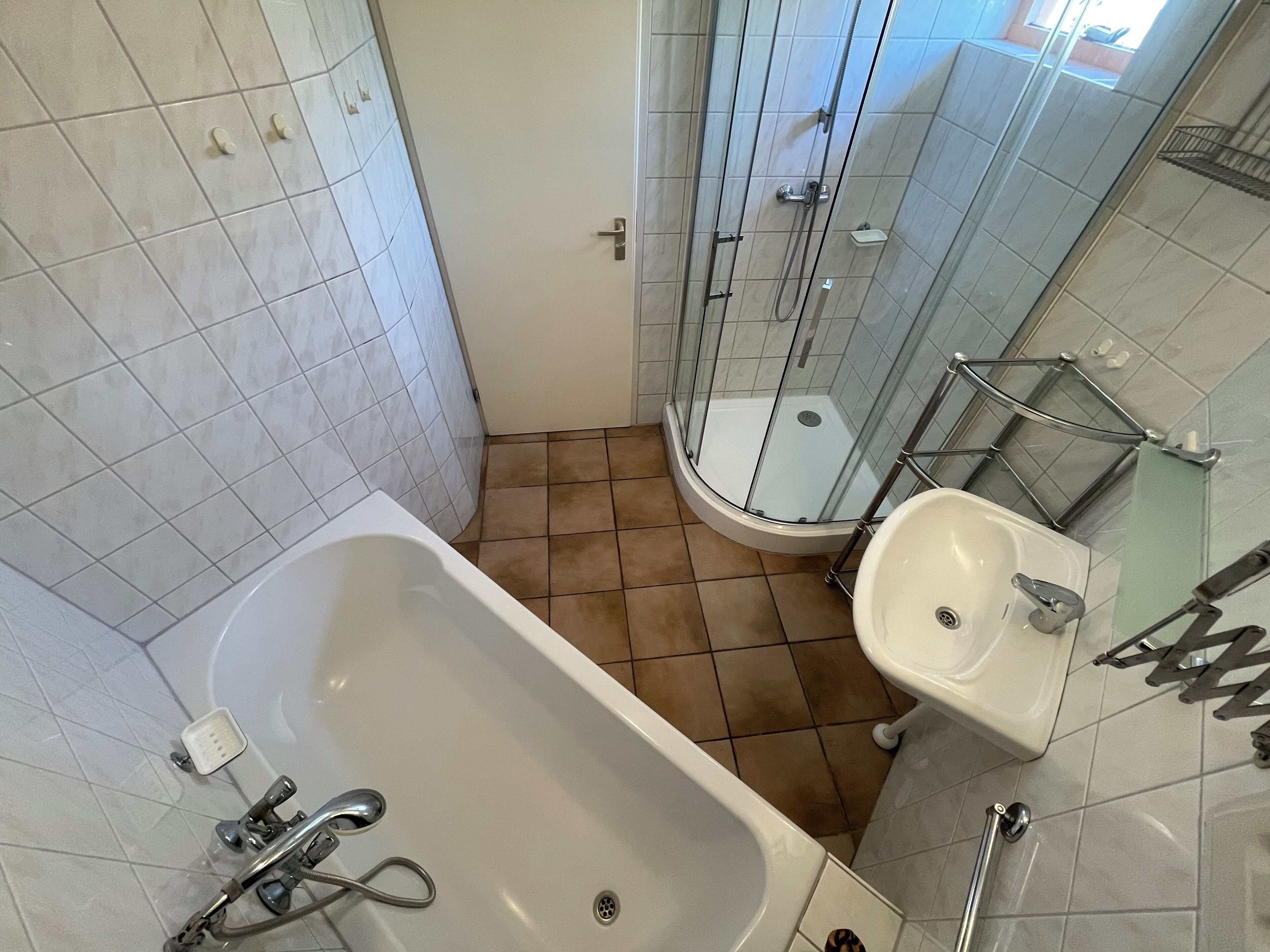 Une salle de bain équipée d’une baignoire, d’un lavabo et d’une cabine de douche en verre.