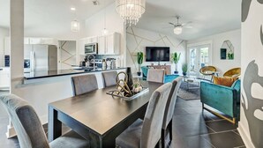 A modern kitchen with white cabinets, a central island, and a chandelier. - NAS Jax Pool Hot-tub Gameroom Message for Spring (Jacksonville)