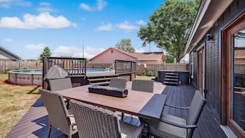 Relax in style on the spacious deck with a table and comfortable wicker chairs, featuring a hot tub for ultimate relaxation.