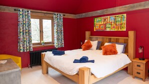 A bedroom with a wooden bed, a window with curtains, a radiator, and a small bedside table with a lamp. - Jossies Snug - peaceful, private garden/hot tub, swimming lake, Spa and Wellness (Bletchingley)