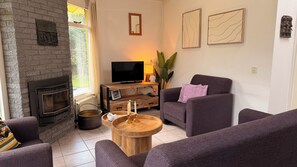 A living room with a fireplace, a TV, and a sofa.