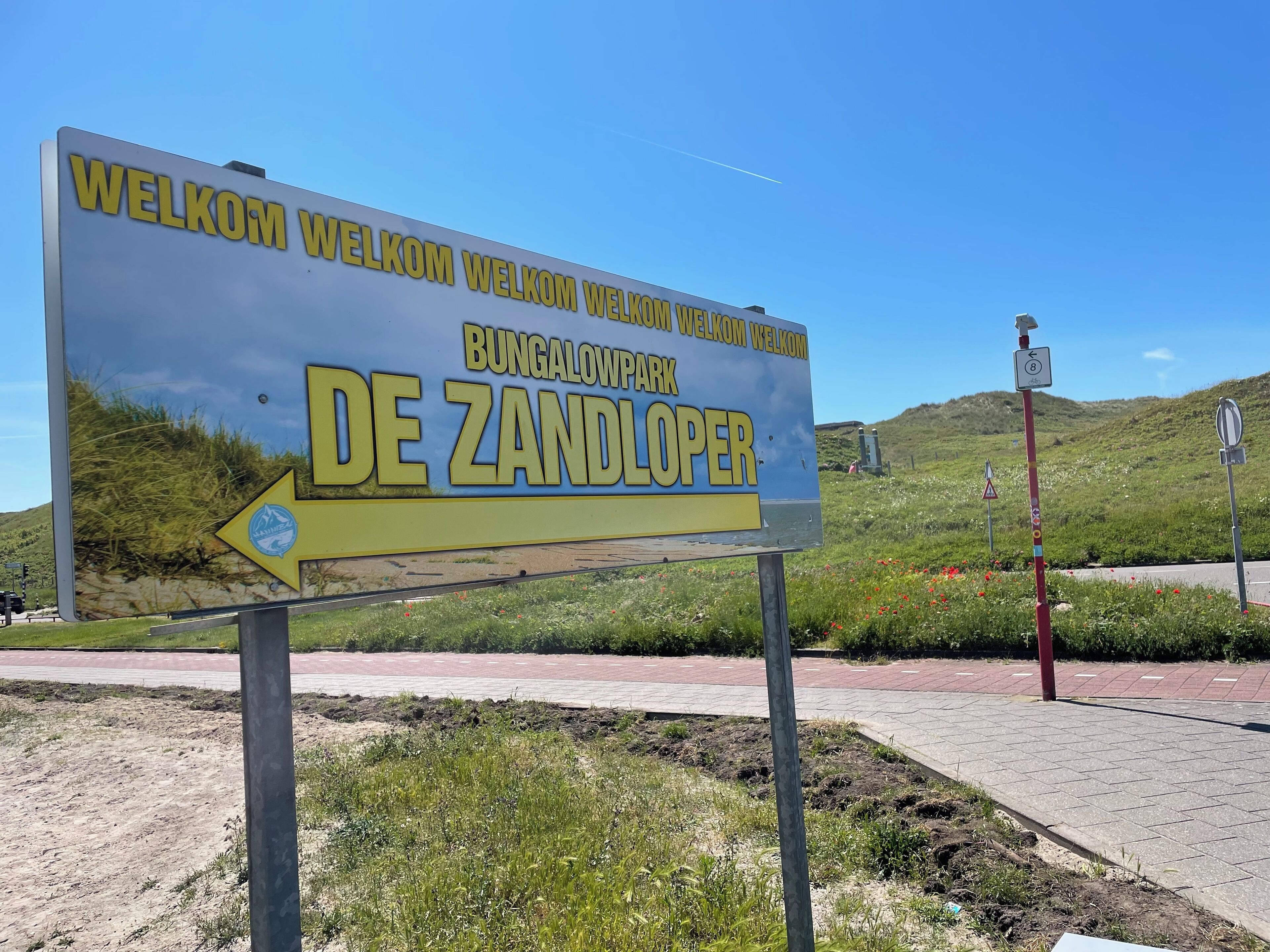 Velkomstskilt for campingpladsen De Zandloper med en piletavle.