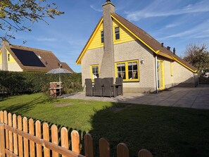 A house with a brick exterior, a chimney, and a yellow-framed window. - 3 bedroom accommodation in Julianadorp aan Zee (Julianadorp aan Zee)