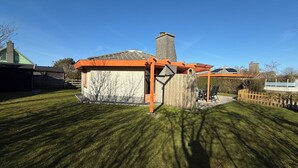 Ein kleines, eingeschossiges Haus mit Ziegelaußenwand und geneigtem Dach.