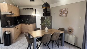 Eine moderne Küche mit Holzausstattung, inklusive Einbauherd und Essbereich mit Holztisch und Stühlen.