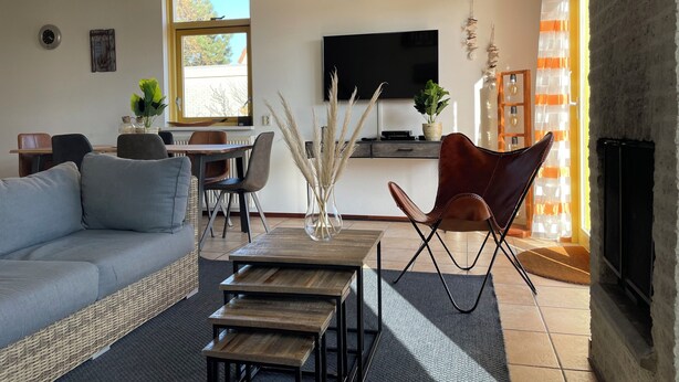 A living room with a sofa, a coffee table, a TV, and a fireplace. - 3 bedroom accommodation in Julianadorp aan Zee (Julianadorp aan Zee)