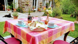 Un área de comedor al aire libre con una mesa para dos, rodeada de sillas.