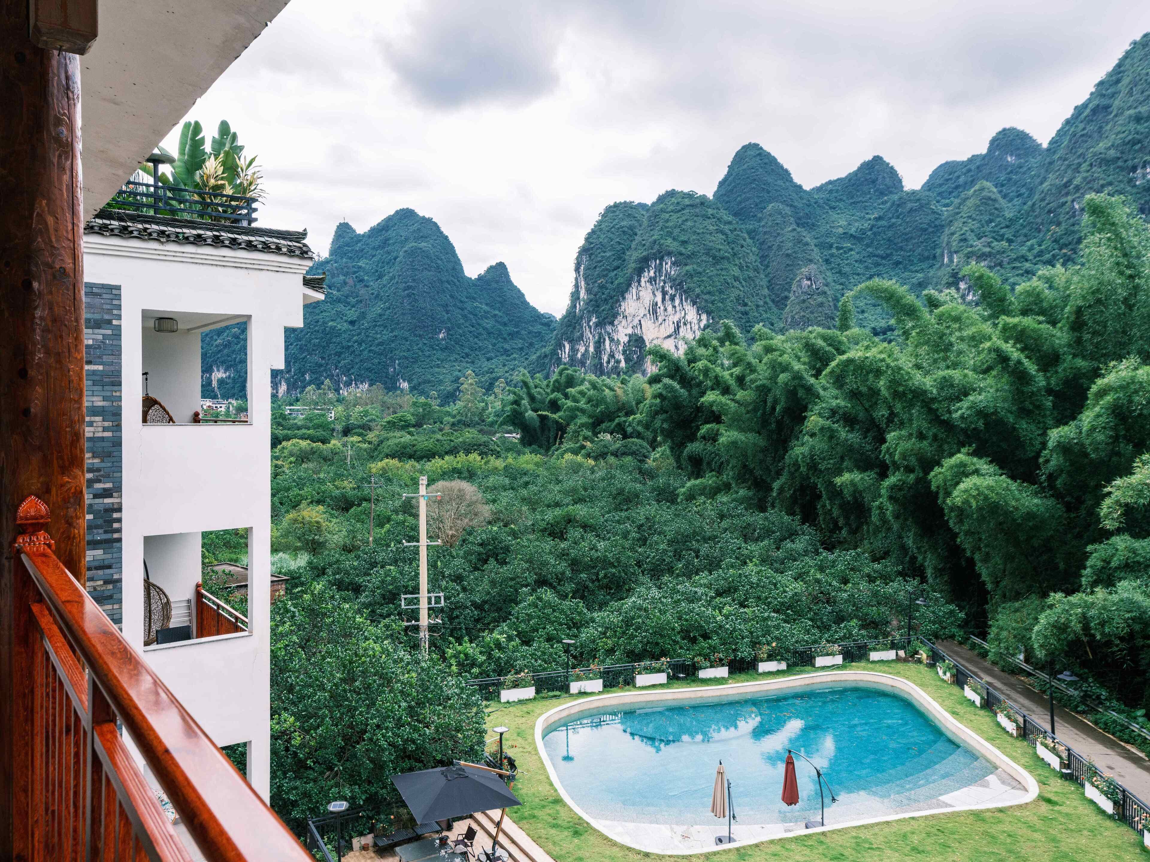 A pool area with a view of mountains and lush greenery.