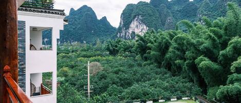 A pool area with a view of mountains and lush greenery.