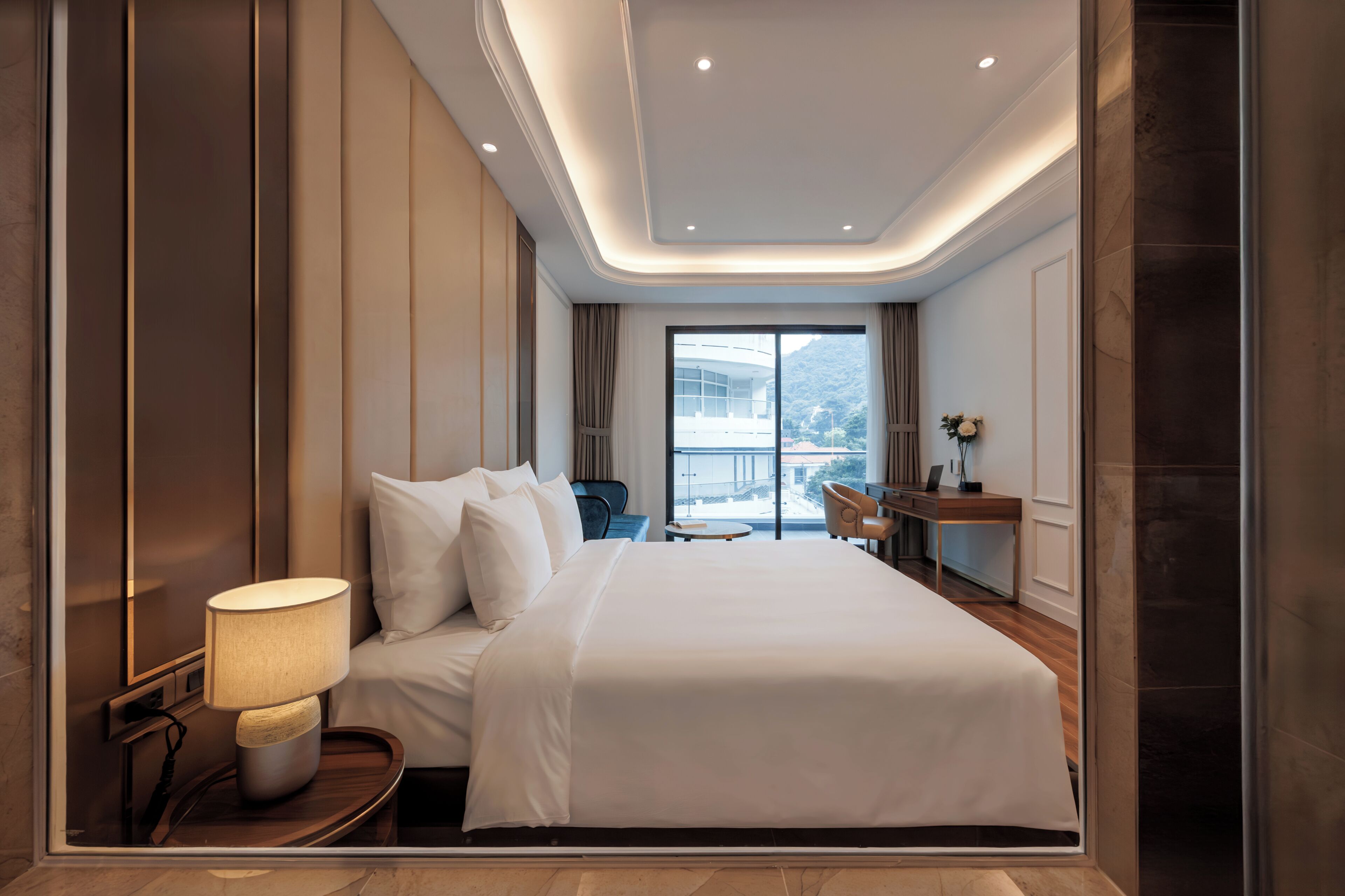 Une chambre d’hôtel moderne avec un grand lit, un bureau et une vue sur la montagne.