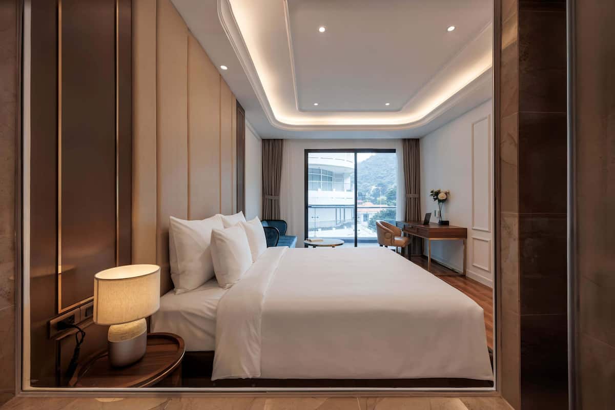 Une chambre d’hôtel moderne avec un grand lit, un bureau et une vue sur la montagne.