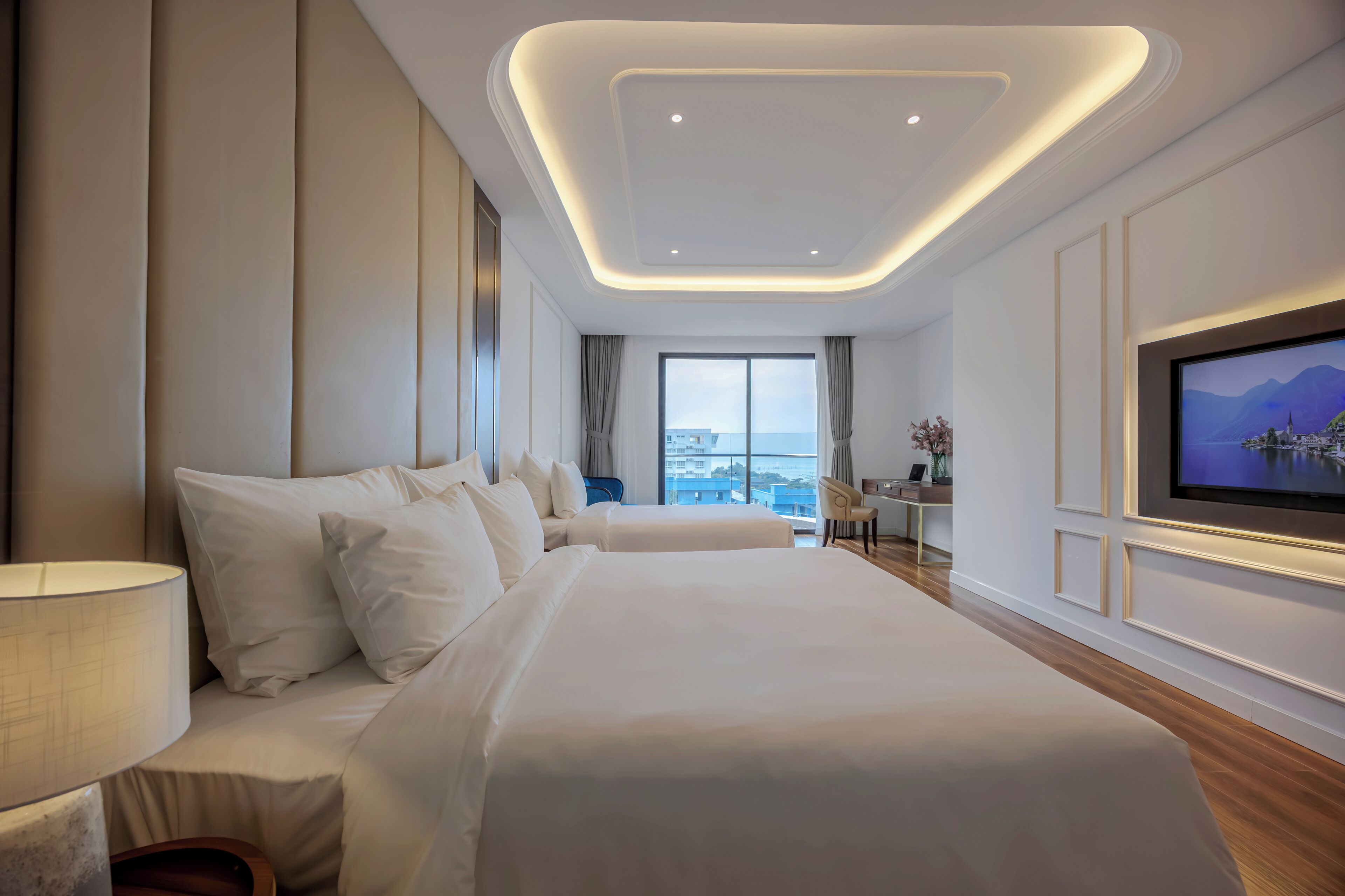 Une chambre d’hôtel moderne avec un grand lit, une télévision et une vue sur la ville.