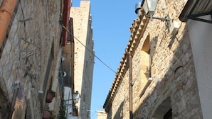 A narrow street with stone buildings, a visible staircase, and a clear blue sky. - B&B Sotto le Mura Wellness (Pietramontecorvino)