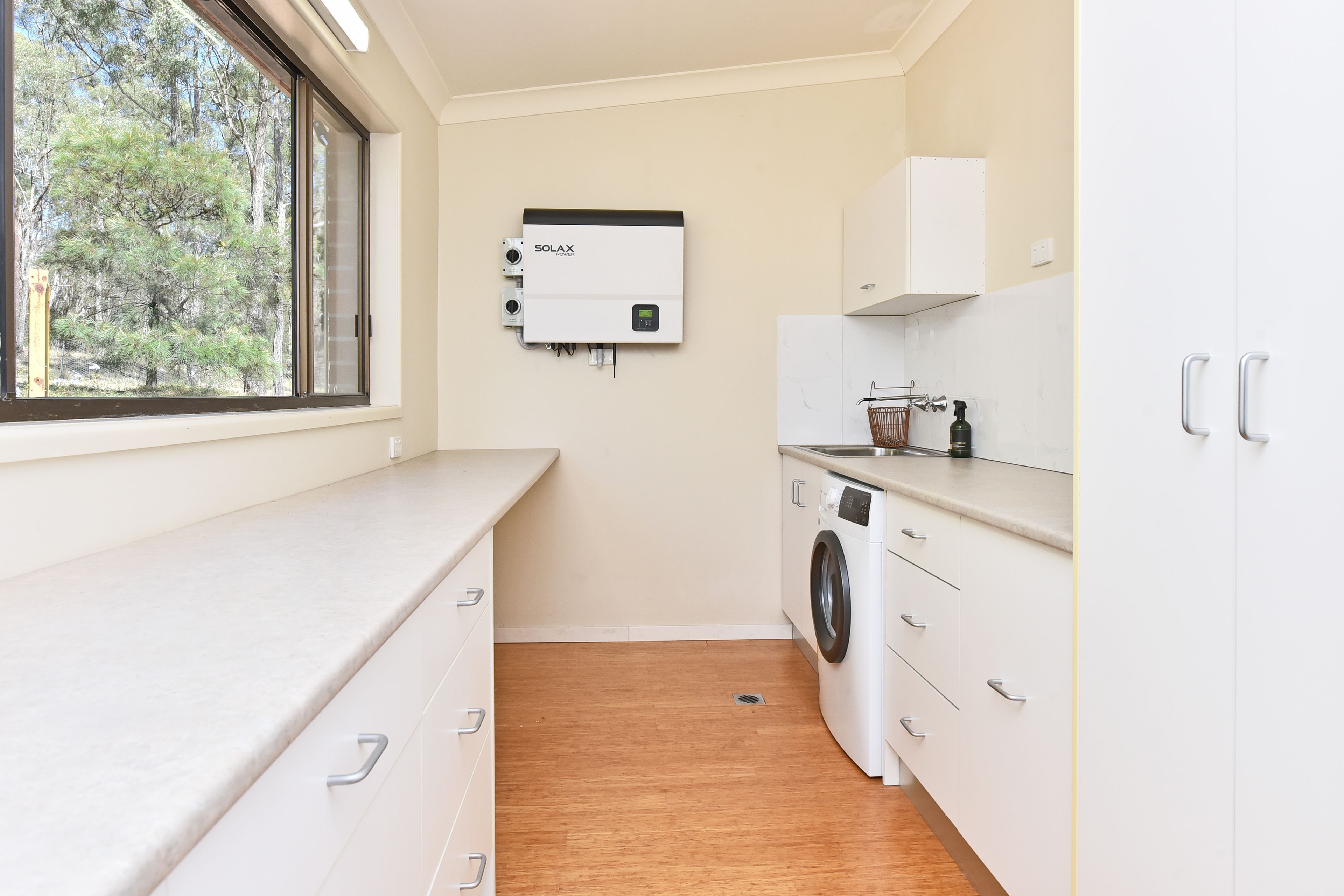 A compact laundry room with a washing machine, a dryer, and a water heater.