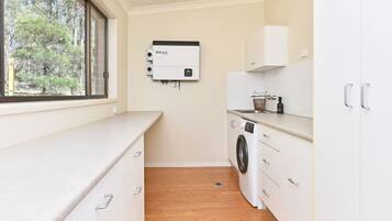 A compact laundry room with a washing machine, a dryer, and a water heater.