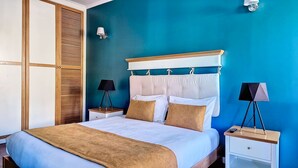Une chambre à coucher avec un lit, des tables de chevet, une lampe et une armoire.