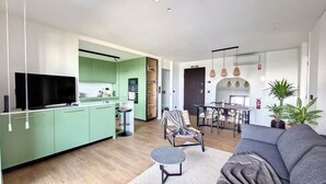 Een modern appartement met keuken, eethoek en zithoek.