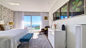 Una habitación de hotel moderna con una cama grande, un área de descanso y un escritorio.