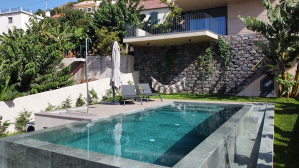 A swimming pool with a stone wall and a hammock. - Serenity Valley Escape by LovelyStay (Ribeira Brava)