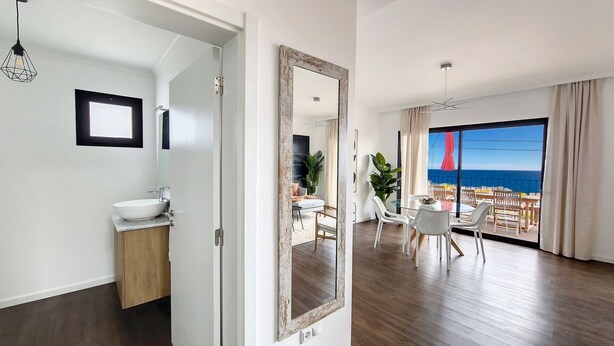 A modern apartment with a bathroom, a dining area with a view of the sea, and a balcony. - Costa Vista by LovelyStay (Funchal)